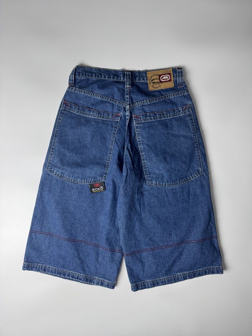 Ecko Unltd Denim Shorts Long Jorts (Category: Shorts) located in Cavite. Submitted by dracokidstuff (Listing ID 1465085584, Image 2). Description: - Brand: Ecko Unltd - Style: Vintage Y2K baggy skater denim jorts - Wash: Dark blue with contrast red topstitching - Features: Large front cargo pockets with khaki flaps, rhino logo, web branding, and back leather waistband patch - Size: Flat waist measures roughly 15 inches across.