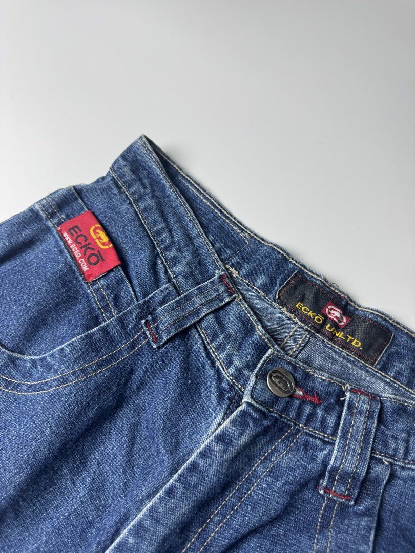 Ecko Unltd Denim Shorts Long Jorts (Category: Shorts) located in Cavite. Submitted by dracokidstuff (Listing ID 1465085584, Image 3). Description: - Brand: Ecko Unltd - Style: Vintage Y2K baggy skater denim jorts - Wash: Dark blue with contrast red topstitching - Features: Large front cargo pockets with khaki flaps, rhino logo, web branding, and back leather waistband patch - Size: Flat waist measures roughly 15 inches across.