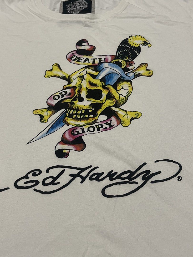 Ed Hardy White Graphic Tee (Complete Tag) (Category: Tshirts & Polo Shirts ) located in Las Pinas. Submitted by 5.1.5kurono (Listing ID 1465149988, Image 2). Description: Available ✅ Ed Hardy Tee ₱200 • width: 22 • length: 27 Issue: • pinhole near tag • needs wash since na stock lang 📍 las piñas, ph • j&t / lalamove 📦 • sf shouldered by buyer • gcash only 💸 (payment first) color may vary due to lighting all items are thrifted please manage you