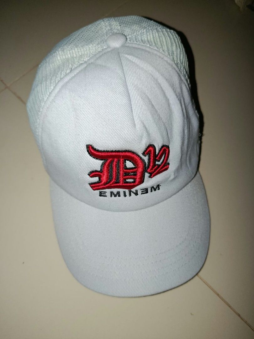 Eminem D12 White Trucker Cap Hat (Category: Caps & Hats) located in Bacolod City. Submitted by jimar4955 (Listing ID 1465025634, Image 1). Description: - Official D12 x Eminem merchandise - Color: White with red and black embroidered logo - Classic trucker design with breathable mesh back panels - Structured front crown and curved brim - Material: 80% acrylic, 20% wool - Size: One size fits all (adjustable) - Origin: Made in Korea - Condition: Br