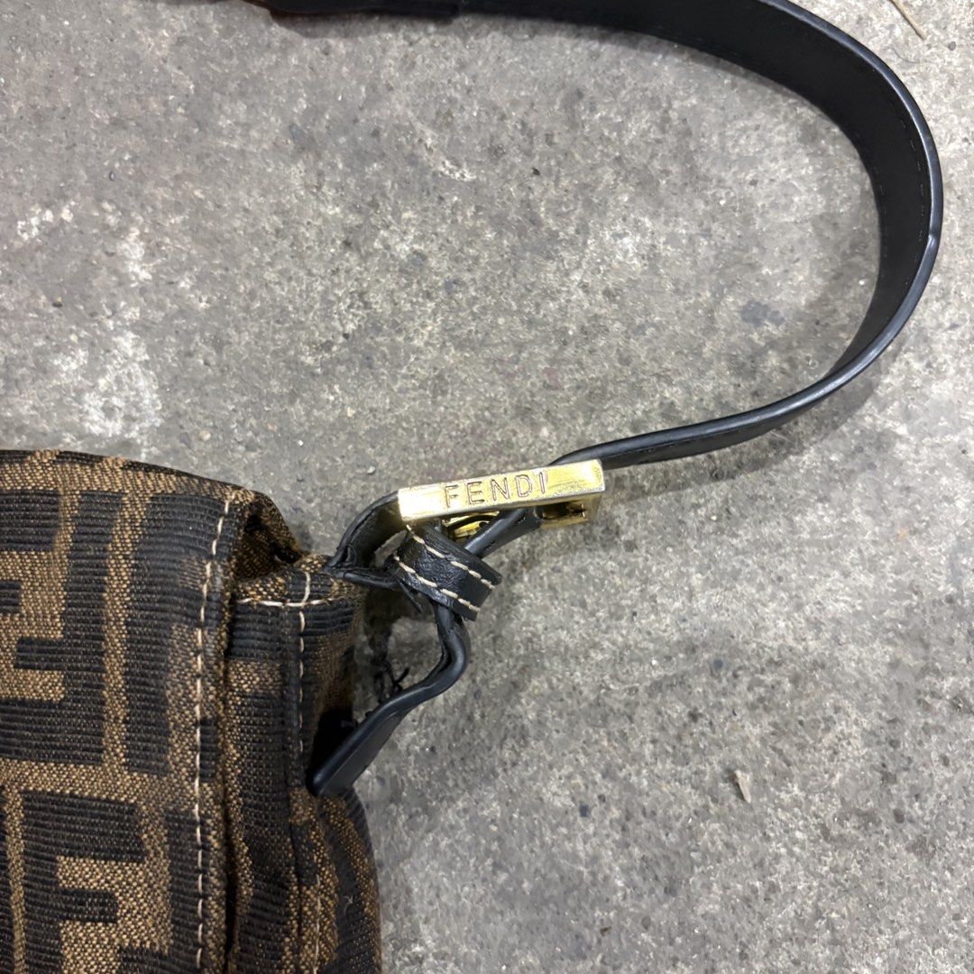 Fendi Mini Zucca FF Baguette (Category: Luxury Bags & Wallets) located in Zamboanga. Submitted by thriftyyali (Listing ID 1465100795, Image 3). Description: - Authentic Fendi Zucca canvas pattern in classic brown and black - Sleek black leather strap and front magnetic flap closure - Elegant gold-tone hardware with engraved FENDI lettering - Stamped 'Made in Italy' tag near the front lock mechanism - Perfect luxury everyday or statement bag.