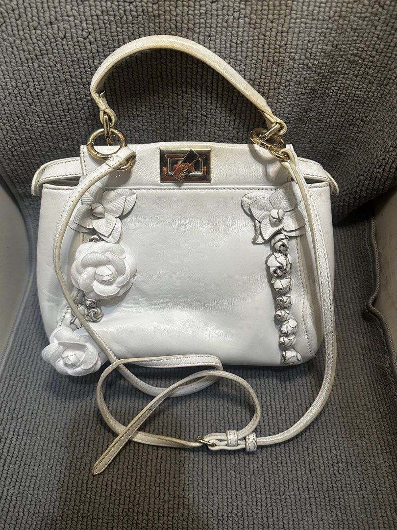 Fendi Peekaboo (Category: Luxury Bags & Wallets) located in Quezon City. Submitted by la.deals (Listing ID 1465022130, Image 2). Description: Authentic FENDI PEEKABOO - Brand: Fendi - Color: White with gold-tone hardware - Design: 3D leather flower appliques on the front - Closure: Twist-lock with engraved Fendi logo - Straps: Top handle and adjustable shoulder strap - Condition: Pre-loved with some wear and scuffing on the white leather, handles