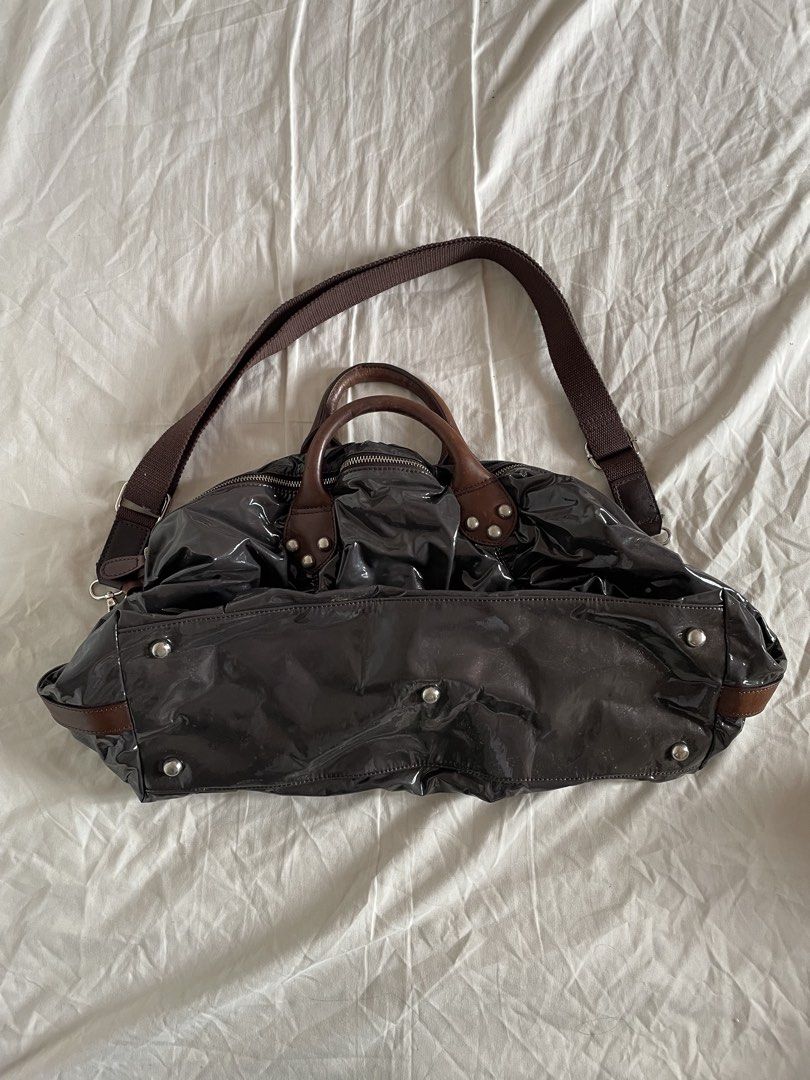 Fiorucci Large Dumpling Sling Bag (Category: Shoulder Bags) located in Bacoor. Submitted by j0skopo (Listing ID 1465038830, Image 2). Description: - Brand: Fiorucci - Size: Large - Color: Dark purple with a glossy patent finish - Straps: Dual top carry genuine leather handles, and an adjustable fabric crossbody strap - Hardware: Silver-tone with engraved brand details and protective metal base feet - Interior: Spacious fabric-lined compartment wi