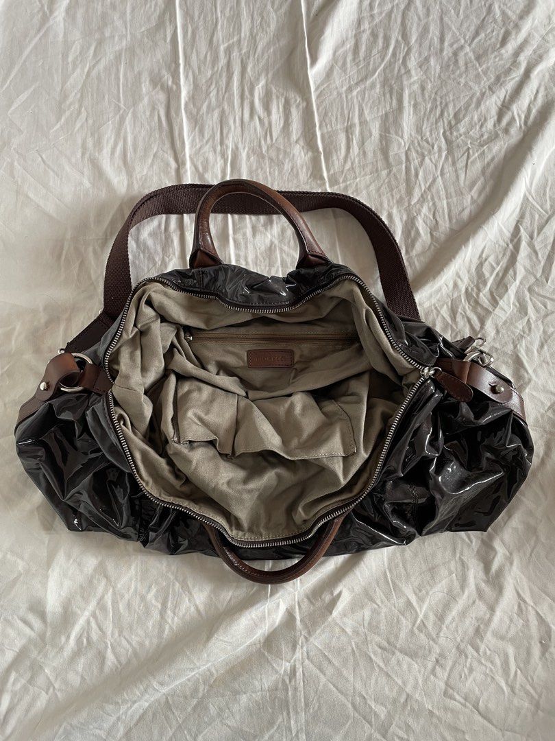 Fiorucci Large Dumpling Sling Bag (Category: Shoulder Bags) located in Bacoor. Submitted by j0skopo (Listing ID 1465038830, Image 3). Description: - Brand: Fiorucci - Size: Large - Color: Dark purple with a glossy patent finish - Straps: Dual top carry genuine leather handles, and an adjustable fabric crossbody strap - Hardware: Silver-tone with engraved brand details and protective metal base feet - Interior: Spacious fabric-lined compartment wi
