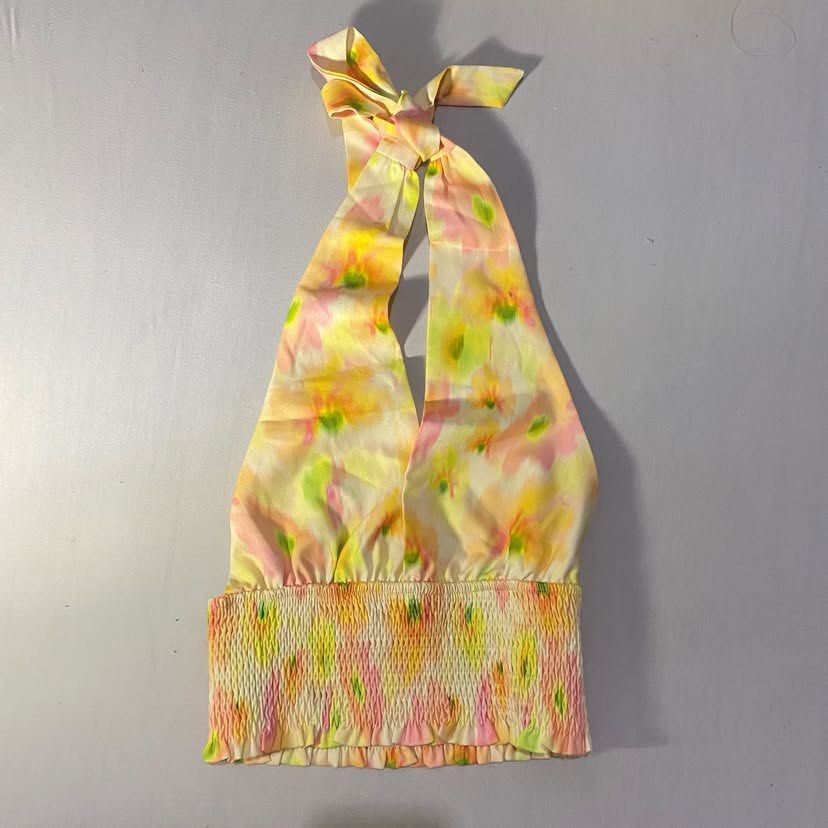 Floral Halter Top Smocked Hem (Category: Sleeveless) located in Antipolo. Submitted by luvbia (Listing ID 1465116058, Image 1). Description: - Vibrant floral print in pink, yellow, and green - Halter style with adjustable tie at the back of the neck - Wide smocked elastic band at the bottom hem for a secure, comfortable fit - Made from soft, lightweight fabric ideal for hot weather - Perfect for summer outings, vacations, and beach trips.