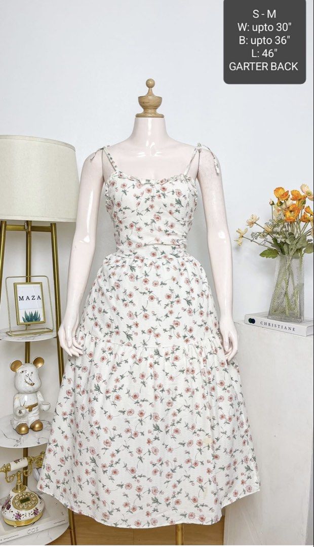 Floral midi dress (Category: Dresses) located in Bacoor. Submitted by clairenw68192 (Listing ID 1465081698, Image 1). Description: - Style: White midi dress with sweet pink flowers - Details: Spaghetti straps with shoulder ties, - Comfort: Smocked back design for an easy, flexible fit - Size: Best fits Small to Medium - Measurements: Bust up to 36" | Waist up to 30" | Length 46".