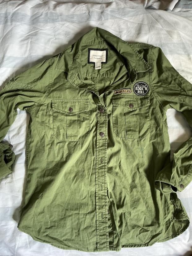 Forever 21 Green Rock 'n' Roll Button-Up Shirt (Category: Shirts) located in Manila. Submitted by ellee.stone (Listing ID 1465075544, Image 1). Description: - Brand: Forever 21 - Color: Olive Green - Style: Casual utility button-up shirt with long sleeves and button cuffs - Details: Dual chest pockets and cool embroidered rock and roll patches near the collar and chest - Condition: Excellent / Pre-loved - Mode of Payment: GCash - Shipping: Ships 