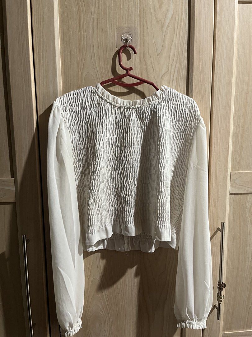 Forever 21 White Smocked Long Sleeve Blouse (Category: Longsleeves) located in Tubigon. Submitted by dewyclick (Listing ID 1465016898, Image 1). Description: - Brand: Forever 21 - Size: S (fits true to size) - Color: White - Details: Smocked bodice, textured fabric, ruffle neckline, sheer sleeves with gathered cuffs, and back zipper closure - Style: Wardrobe basic, pairs easily with jeans or skirts - Condition: Great pre-loved condition.