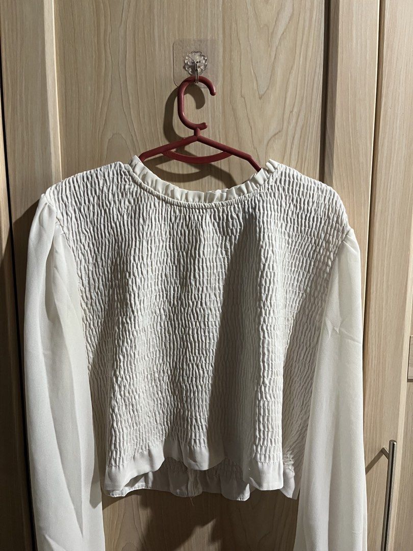 Forever 21 White Smocked Long Sleeve Blouse (Category: Longsleeves) located in Tubigon. Submitted by dewyclick (Listing ID 1465016898, Image 2). Description: - Brand: Forever 21 - Size: S (fits true to size) - Color: White - Details: Smocked bodice, textured fabric, ruffle neckline, sheer sleeves with gathered cuffs, and back zipper closure - Style: Wardrobe basic, pairs easily with jeans or skirts - Condition: Great pre-loved condition.