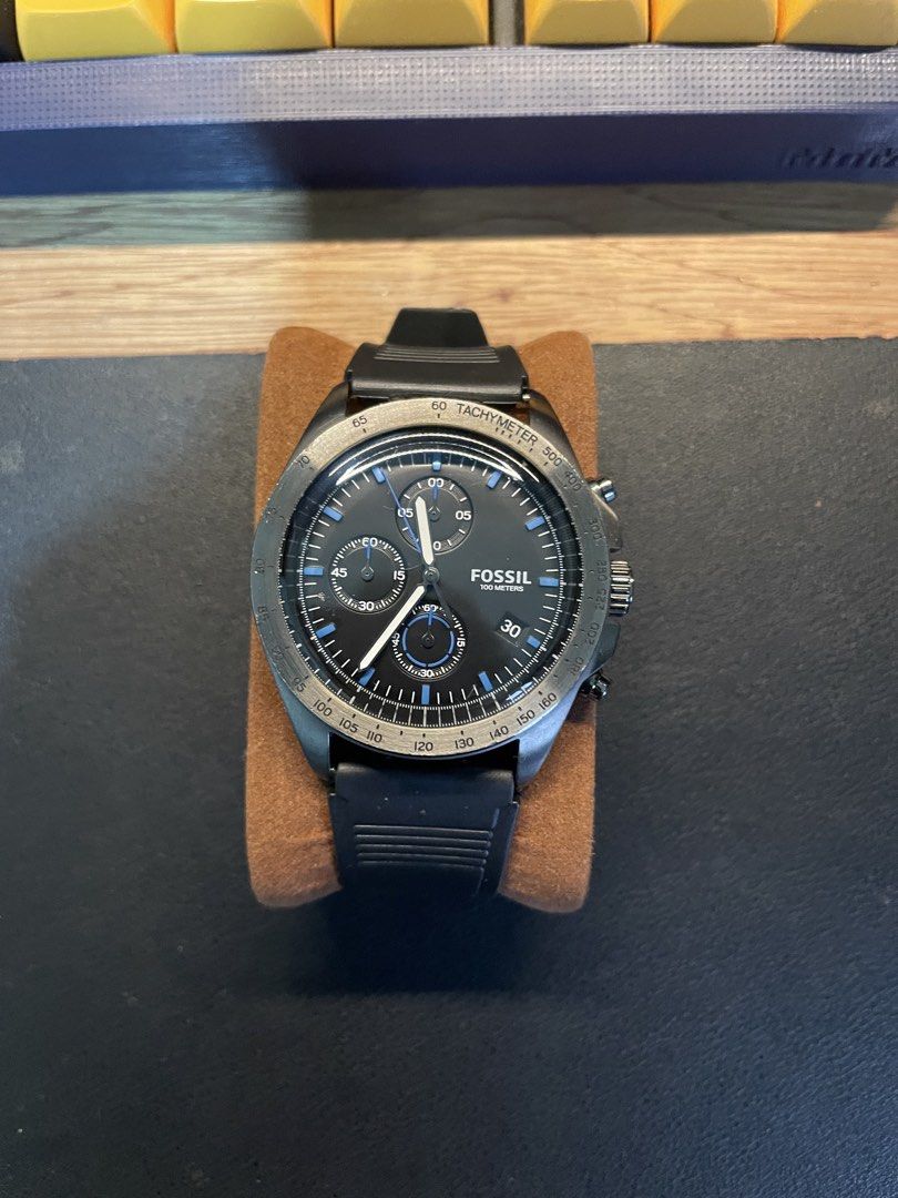 Fossil 100 Meters Chronograph Watch (Category: Men's Watches) located in San Carlos. Submitted by kedecop (Listing ID 1465081319, Image 1). Description: - Brand: Fossil - Style: Chronograph watch - Dial: Textured black with striking blue markers and 3 sub-dials - Bezel: Tachymeter bezel - Date Display: Located near the 4 o'clock position - Strap: Durable textured rubber strap with buckle closure - Condition: Well-maintained, ready to wear - Perfe