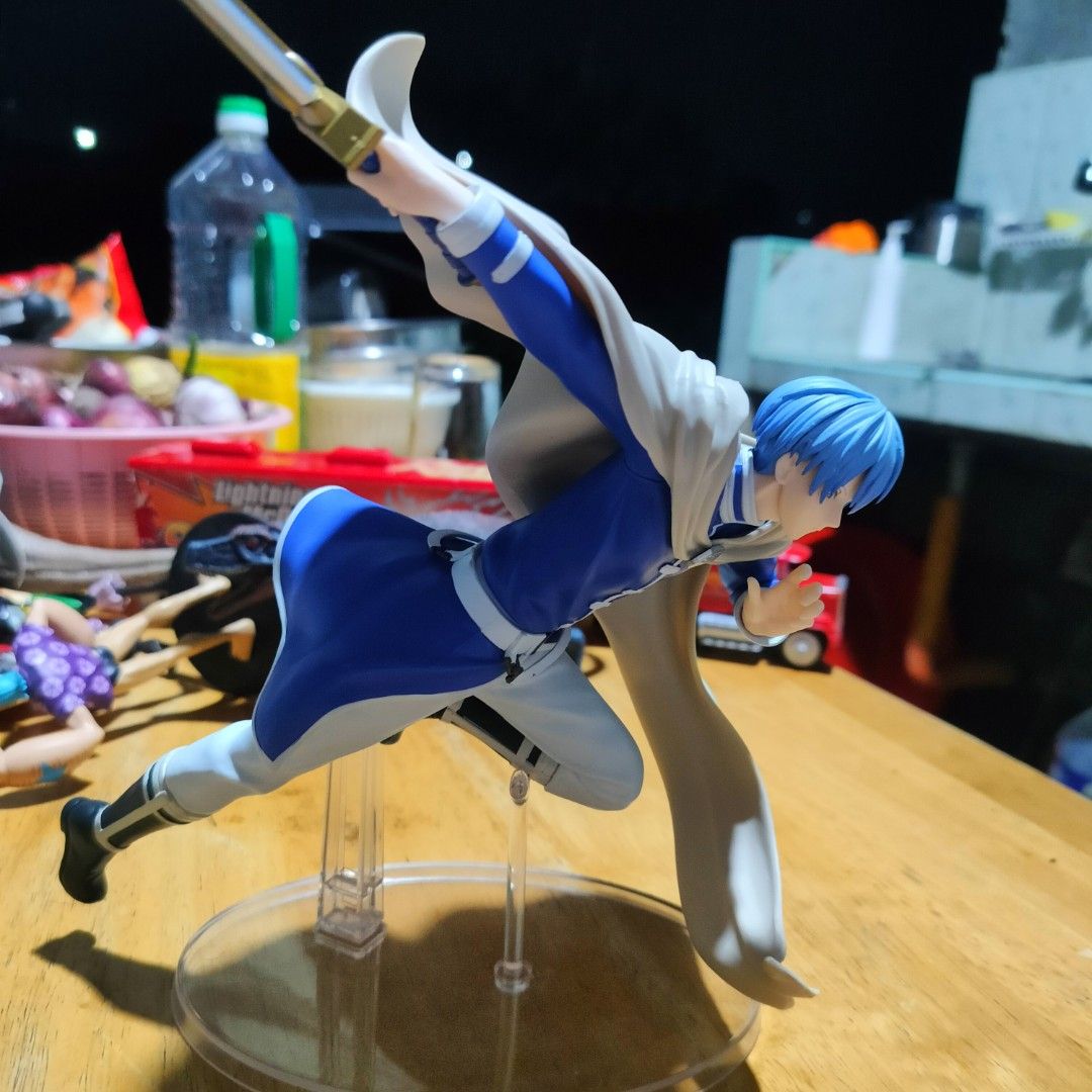Frieren Himmel Action Figure Dynamic Pose with Sword (Category: Figurines & Statues) located in Plaridel. Submitted by klayskolektibols (Listing ID 1465090901, Image 2). Description: - Character: Himmel from Frieren - Material: Dynamic PVC figure - Details: Blue hair, blue mage outfit, flowing white cape, and blue-bladed sword mid-action - Stand: Clear round base with support stems for secure display - Condition: Clean piece with great paint deta