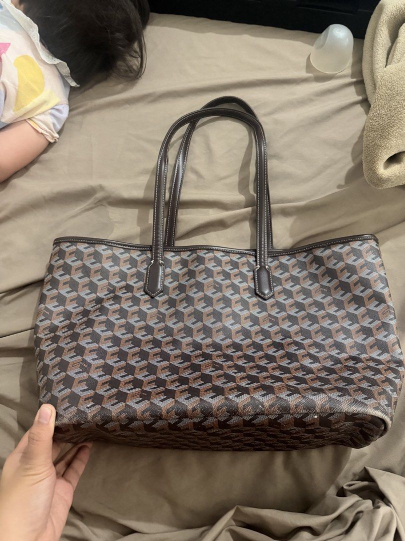 Geometric Pattern Tote Bag Brown Grey (Category: Tote Bags) located in Manila. Submitted by susanamama (Listing ID 1465169877, Image 1). Description: - Design: Stylish brown and grey geometric pattern - Straps & Trim: Durable dark brown leather handles and accents - Interior: Cream canvas lining with minor stains near the bottom - Structure: Includes a dark brown base insert and a sturdy, structured bottom panel - Condition: Clean exterior canvas