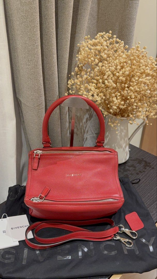 Givenchy Pandora Red Leather Handbag (Category: Luxury Bags & Wallets) located in Quezon City. Submitted by mamadeclutter8877 (Listing ID 1465085672, Image 2). Description: Givenchy Pandora bag in striking red textured leather. Includes the detachable shoulder strap, original dust bag, and store tags. Distinctive boxy shape with top zip closure and silver-tone hardware. Interior lined in neutral canvas with zip and slip pockets. Made in Italy. Gr