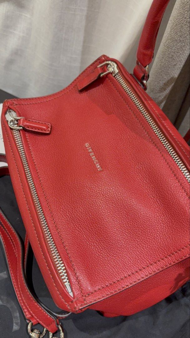 Givenchy Pandora Red Leather Handbag (Category: Luxury Bags & Wallets) located in Quezon City. Submitted by mamadeclutter8877 (Listing ID 1465085672, Image 3). Description: Givenchy Pandora bag in striking red textured leather. Includes the detachable shoulder strap, original dust bag, and store tags. Distinctive boxy shape with top zip closure and silver-tone hardware. Interior lined in neutral canvas with zip and slip pockets. Made in Italy. Gr