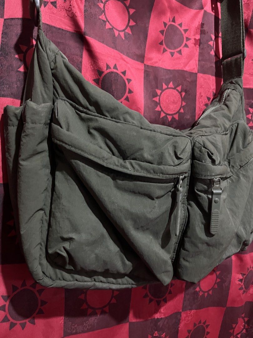 Green Nylon Messenger Bag (Category: Sling Bags) located in Cabuyao City. Submitted by jebsology (Listing ID 1465137230, Image 2). Description: - Color: Dark green - Material: Soft, slouchy nylon - Closure: Secure zippered main compartment - Pockets: Two front flap zippered pockets and side zipper compartments - Strap: Adjustable for custom fit - Capacity: Spacious interior for phone, keys, wallet, and daily essentials - Style: Unisex, casual eve