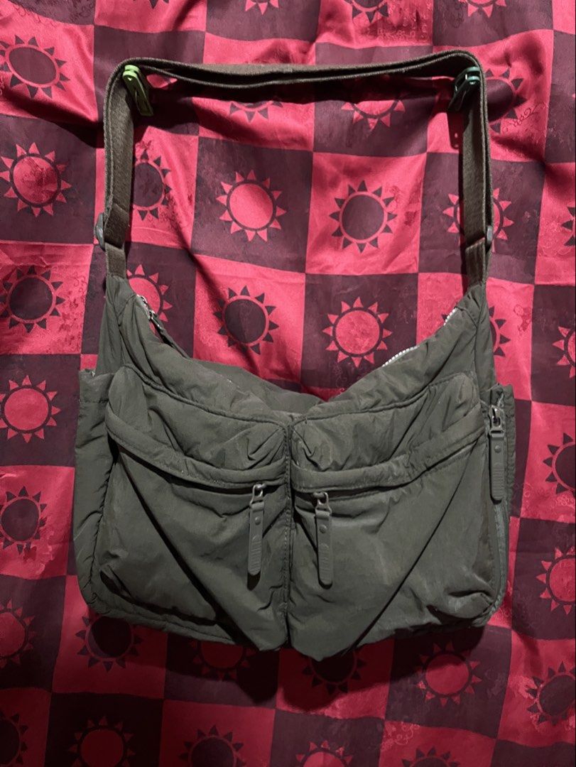 Green Nylon Messenger Bag (Category: Sling Bags) located in Cabuyao City. Submitted by jebsology (Listing ID 1465137230, Image 1). Description: - Color: Dark green - Material: Soft, slouchy nylon - Closure: Secure zippered main compartment - Pockets: Two front flap zippered pockets and side zipper compartments - Strap: Adjustable for custom fit - Capacity: Spacious interior for phone, keys, wallet, and daily essentials - Style: Unisex, casual eve