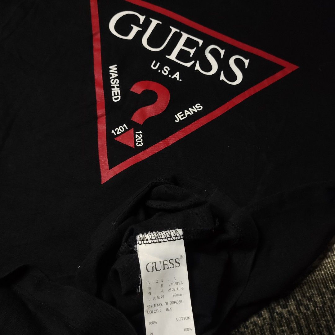 Guess Tshirt (Category: Blouses) located in Taguig. Submitted by althriftdailyloots94 (Listing ID 1465143241, Image 2). Description: - Brand: GUESS - Color: Black with bold red and white triangle logo print - Size: L (Regular Fit) - Material: 100% Cotton - Design: Classic crew neck, short sleeves - Style Number: YH2K9405K - Condition: Great basic top, easy to style with denim or shorts - Original.