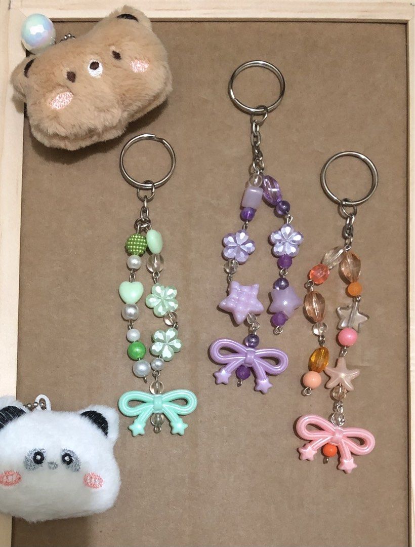 Handmade Beaded Keychains with Bow and Star Charms (Category: Handmade Craft) located in Manila. Submitted by tonettesells (Listing ID 1465106006, Image 1). Description: Handmade beaded keychains featuring cute bows, stars, and colorful acrylic beads. Three different colorways available: mint green, pastel purple, and peach orange. Sturdy split ring attachment on each piece. Great for keys, bags, or lanyards..