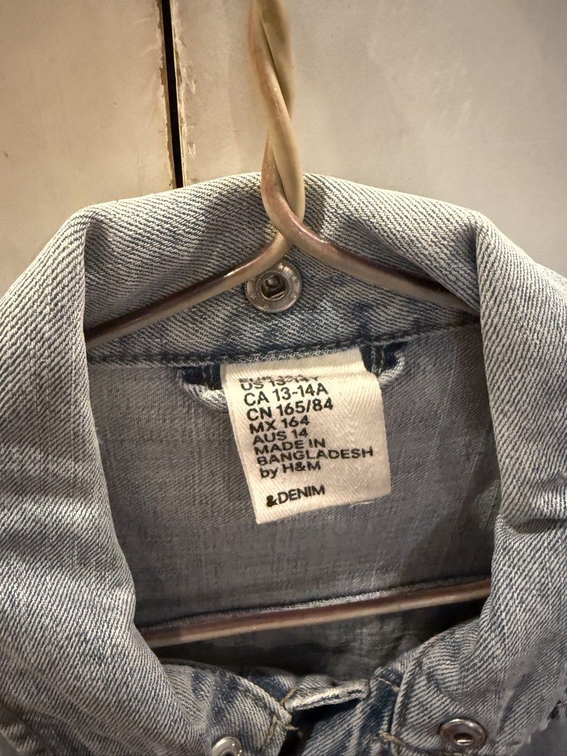 H&M Denim Jacket with Grey Sleeves (Category: Coats, Jackets and Outerwear) located in Manila. Submitted by andromedanny (Listing ID 1465011105, Image 2). Description: - Brand: H&M - Style: Denim jacket with grey jersey sleeves, ribbed cuffs, button-up front, chest pockets, and classic collar - Size: Small - Flaw Note: There are tears and holes on the cuffs of both sleeves.