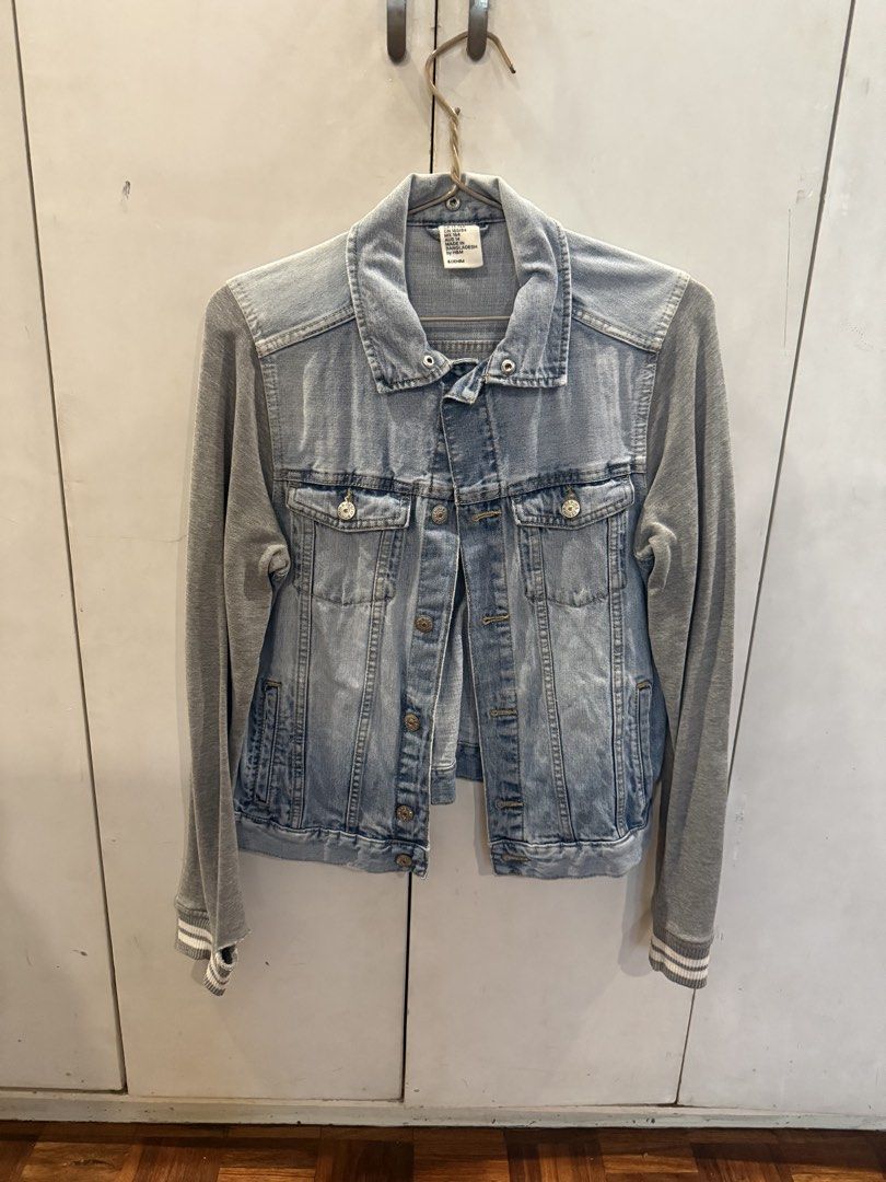 H&M Denim Jacket with Grey Sleeves (Category: Coats, Jackets and Outerwear) located in Manila. Submitted by andromedanny (Listing ID 1465011105, Image 1). Description: - Brand: H&M - Style: Denim jacket with grey jersey sleeves, ribbed cuffs, button-up front, chest pockets, and classic collar - Size: Small - Flaw Note: There are tears and holes on the cuffs of both sleeves.