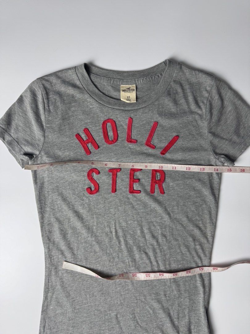 Hollister Grey Graphic Tee Size XS (Category: Shirts) located in Manila. Submitted by babygirly2k (Listing ID 1465080462, Image 3). Description: - Brand: Hollister - Size: Extra Small (XS) - Color: Grey with red embroidered chest lettering - Fit: Classic crew neck, short sleeves - Material: Comfortable cotton blend - Origin: Made in Vietnam - Condition: Clean, excellent everyday basic.