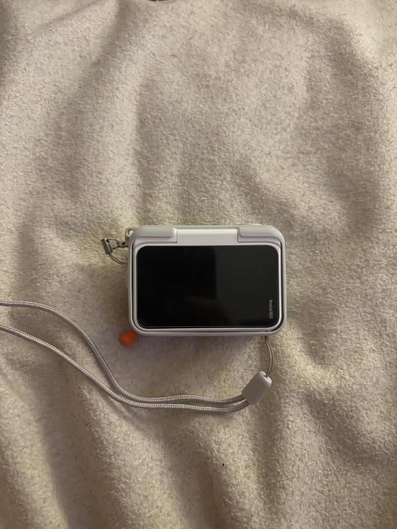 Insta360 GO ultra Action Camera with Case and Lanyard (Category: Cameras) located in Pasig City. Submitted by heyahnggg (Listing ID 1464978076, Image 2). Description: - Model: Insta360 GO Ultra (White) - Condition: Fully functional, ready for vlogging and outdoor shooting - Included Accessories: Protective grey silicone casing, detachable lens cover, box, charger, screen protector, tripod, and matching grey neck lanyard - Key Features: Ultra-comp