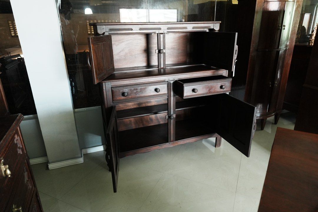 Jacobean- Style Four Door Cupboard (Category: Vintage Collectibles) located in Manila. Submitted by heleensym (Listing ID 1464970435, Image 2). Description: A distinctive dark-finished wooden cupboard featuring four panelled doors, two central drawers, and turned columns framing the upper section. Carved geometric detailing, wooden handles, and traditional turn catches give the piece its character. Upper and lower storage compartments provide roo
