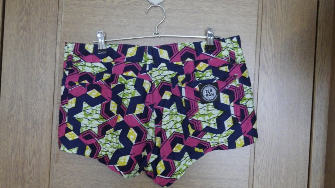 Jekkah African Print Wax Shorts Geometric Pattern (Category: Shorts) located in Taguig. Submitted by spaula76 (Listing ID 1465008402, Image 1). Description: - Brand: Jekkah - Material: Vibrant African wax print fabric - Design: Bold geometric pattern in pink, navy blue, and lime green - Features: Button closure, belt loops, and front/back pockets - Details: Authentic Jekkah cloth label stitched above the right back pocket - Style: Colorful statem