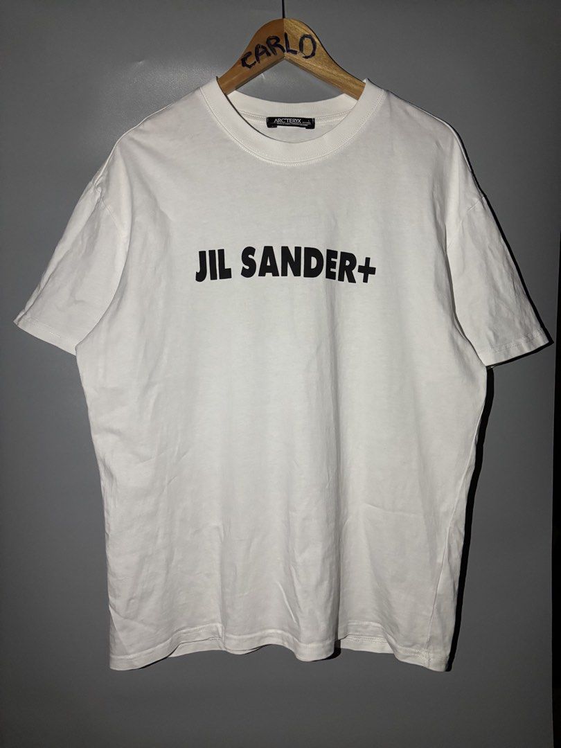 JIL SANDER+ x ARC'TERYX (Category: Tshirts & Polo Shirts ) located in Bayambang. Submitted by lo_keythrifting (Listing ID 1465060284, Image 1). Description: - Brand: Jil Sander+ x Arc'teryx Collaboration - Condition: Good as new - Dimes: 23*28.5 - Color rate: 10/10 - No issue - Item: White Graphic Tee - Size: Large - Details: Large black Jil Sander+ logo on chest, black Arc'teryx skeletal bird graphic on upper back - Material: 100% nylon (see int