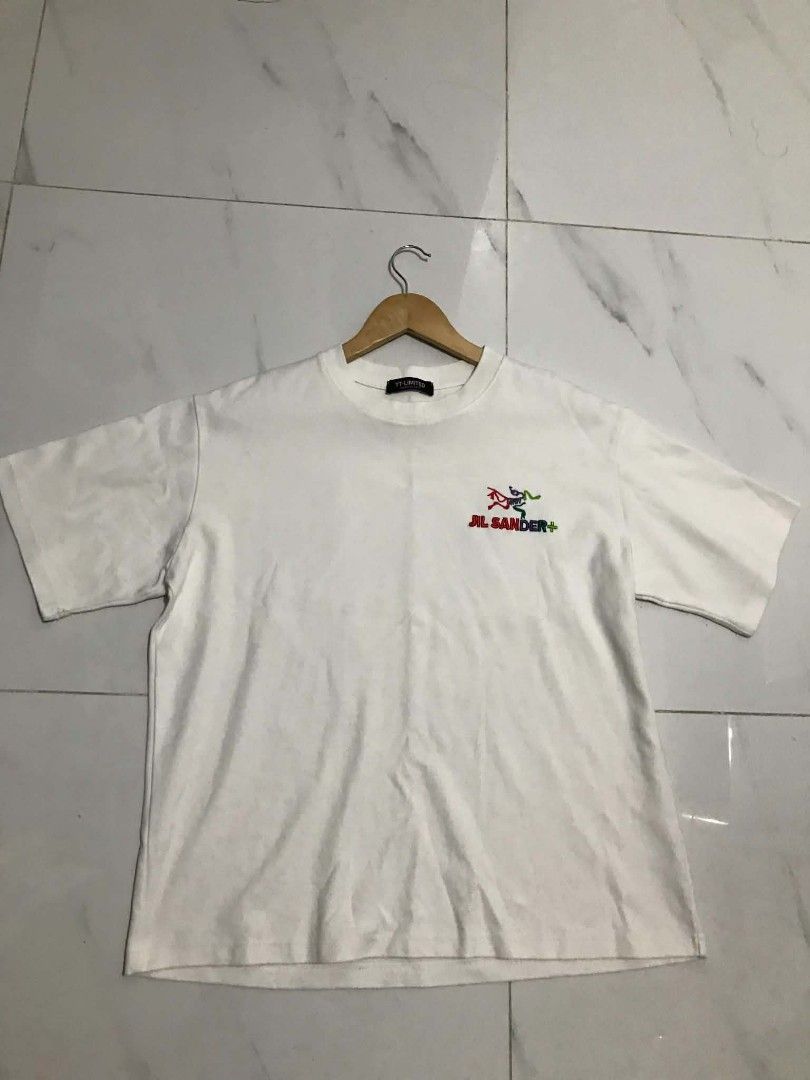 Jil Sander x Arc'teryx White Graphic Tee (Category: Shirts) located in Manila. Submitted by mikeee03 (Listing ID 1465137773, Image 1). Description: - Brand: Jil Sander x Arc'teryx - Color: White - Style: Short sleeve crewneck t-shirt - Details: Embroidered multi-colored chest logo with Jil Sander+ text - Back Design: Large green and dark blue square graphic with Arc'teryx skeletal design - Condition: Good asnew - Sobrang kapal ng tela Need wash o