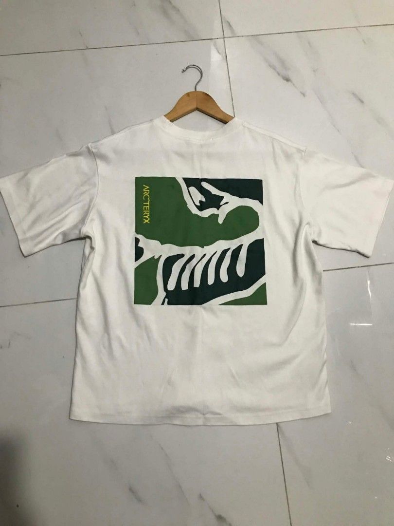 Jil Sander x Arc'teryx White Graphic Tee (Category: Shirts) located in Manila. Submitted by mikeee03 (Listing ID 1465137773, Image 3). Description: - Brand: Jil Sander x Arc'teryx - Color: White - Style: Short sleeve crewneck t-shirt - Details: Embroidered multi-colored chest logo with Jil Sander+ text - Back Design: Large green and dark blue square graphic with Arc'teryx skeletal design - Condition: Good asnew - Sobrang kapal ng tela Need wash o