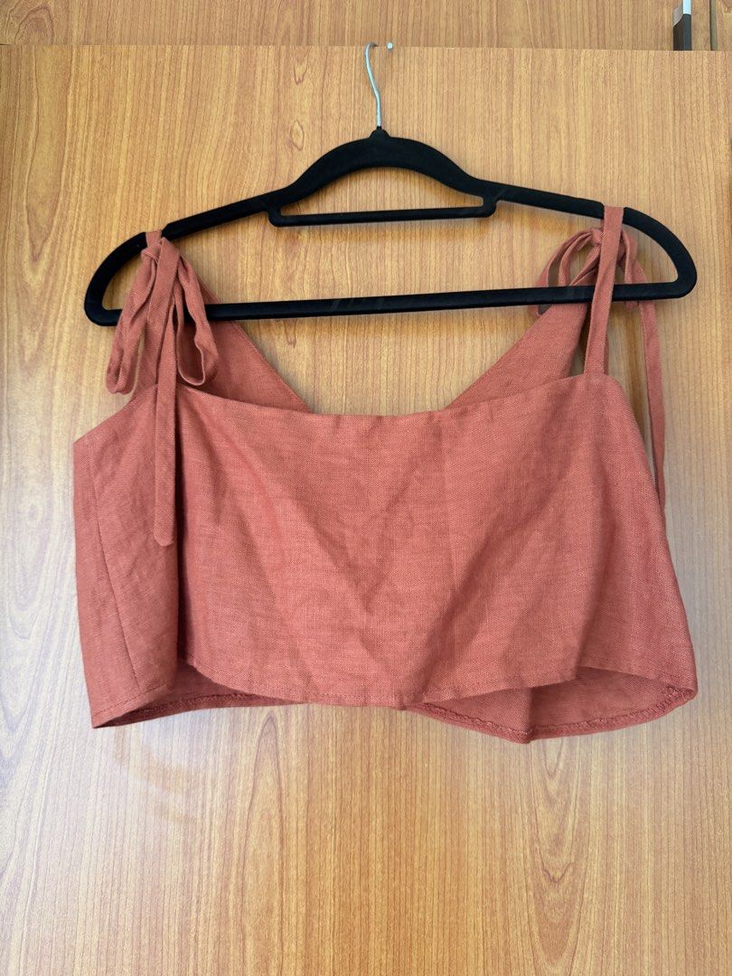 Juanicu Two Way Linen Crop Top (Category: Sleeveless) located in Cavite. Submitted by klarev (Listing ID 1464994467, Image 2). Description: - Brand: Juanicu - Size: Small - Color: Rust orange - Design: Two way top with adjustable tie shoulder straps, v-neck front, and straight back neckline - Condition: Great, worn only a couple of times with no flaws.