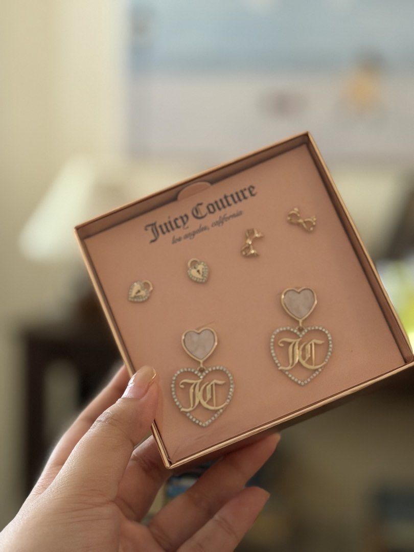 Juicy Couture Heart and Bow Earring Set (Category: Earrings) located in Quezon City. Submitted by ljdgx (Listing ID 1465018066, Image 2). Description: - Brand: Juicy Couture earring set - Condition: Brand new, unworn, in original presentation box - Design: Gold-tone hardware with rhinestone accents, mother-of-pearl look details, and iconic JC monogram logos - Variety: Multiple pairs included featuring dangling hearts, miniature padlocks, and deli