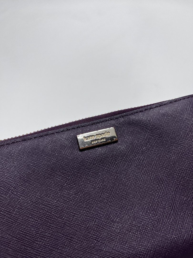 Kate Spade New York Zip Around Wallet (Category: Wallets & Card holders) located in Iloilo. Submitted by fromthebins.ilo2 (Listing ID 1465000473, Image 3). Description: - Brand: Kate Spade New York - Color: Deep purple - Material: Genuine leather with signature pink patterned fabric lining - Closure: Zip-around with a matching wrist strap - Interior Features: Multiple card slots, slip compartments, and a zippered coin pocket - Exterior: Gold meta