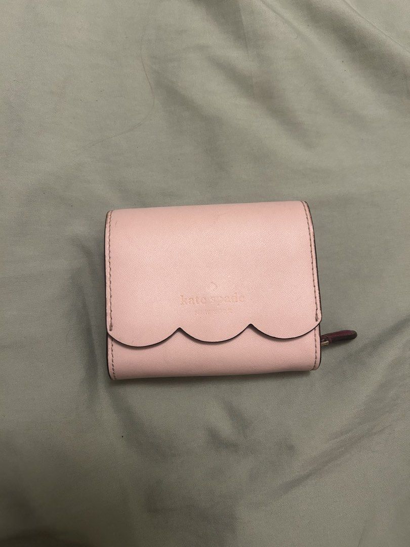 Kate Spade Pink Scallop Wallet (Category: Wallets & Card holders) located in Hermosa. Submitted by dlwrlma00 (Listing ID 1465088904, Image 1). Description: - Brand: Kate Spade - Style: Bifold wallet with chic scalloped flap closure - Color: Pink exterior with a rich deep burgundy interior - Compartments: Multiple card slots, slip pockets, and a secure zippered coin compartment - Hardware & Branding: Elegant gold-tone foil branding stamped on the 