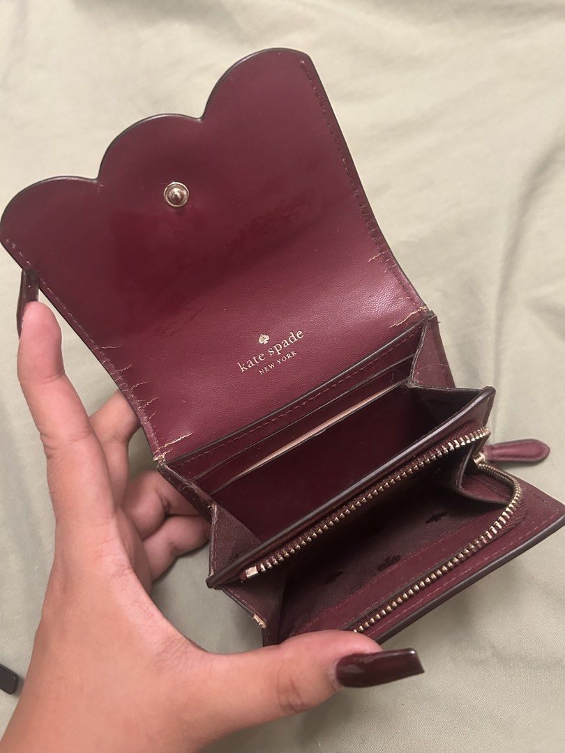 Kate Spade Pink Scallop Wallet (Category: Wallets & Card holders) located in Hermosa. Submitted by dlwrlma00 (Listing ID 1465088904, Image 3). Description: - Brand: Kate Spade - Style: Bifold wallet with chic scalloped flap closure - Color: Pink exterior with a rich deep burgundy interior - Compartments: Multiple card slots, slip pockets, and a secure zippered coin compartment - Hardware & Branding: Elegant gold-tone foil branding stamped on the 
