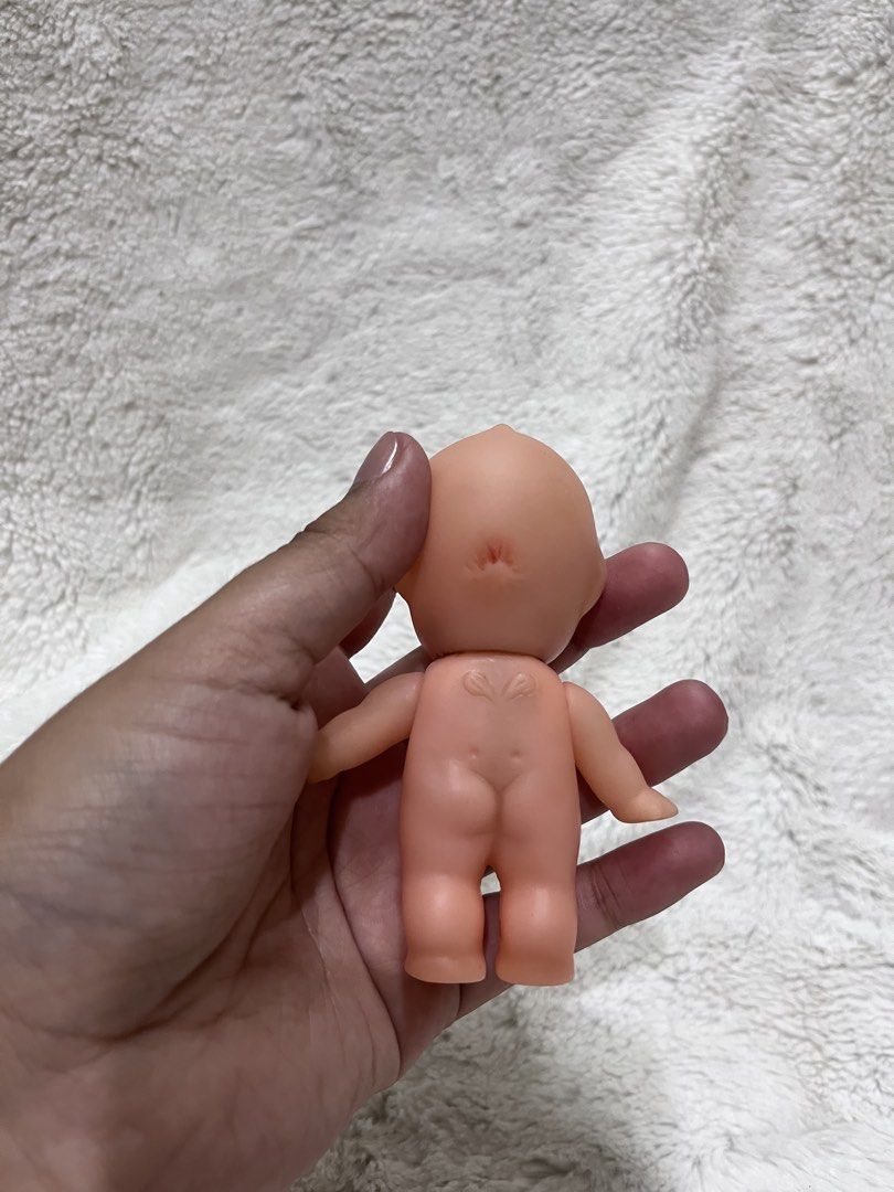 Kewpie Doll (Category: Designer & Blind Box Toys) located in Zamboanga. Submitted by wilthearey91043 (Listing ID 1465002296, Image 2). Description: - Vintage plastic baby doll figure - Peach skin tone with blue painted eyes and red lips - Features a cute winged heart emblem on the back - Stands on its own - Clean overall shape with a tiny mark on the forehead - Perfect retro collectible toy from past decades.