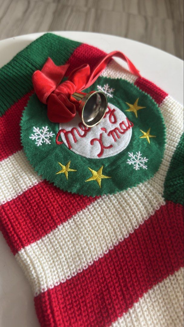 Knitted Christmas Stocking with Wreath and Bell (Category: Handmade Craft) located in Pasig City. Submitted by cecilececile4361 (Listing ID 1464995357, Image 1). Description: - Festive knitted Christmas stocking in red, white, and green stripes - Detailed with a circular felt wreath, embroidered 'Merry X'mas' text, gold stars, and white snowflakes - Accented with a bright red velvet bow and a secure golden bell - Made from thick, high-quality kni