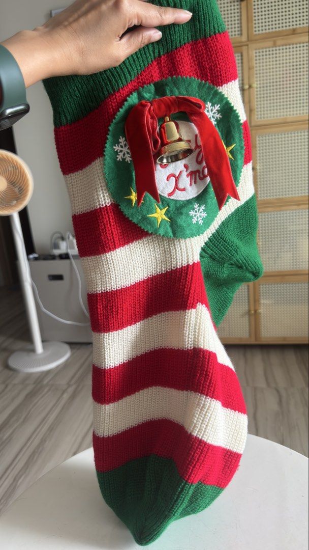 Knitted Christmas Stocking with Wreath and Bell (Category: Handmade Craft) located in Pasig City. Submitted by cecilececile4361 (Listing ID 1464995357, Image 2). Description: - Festive knitted Christmas stocking in red, white, and green stripes - Detailed with a circular felt wreath, embroidered 'Merry X'mas' text, gold stars, and white snowflakes - Accented with a bright red velvet bow and a secure golden bell - Made from thick, high-quality kni