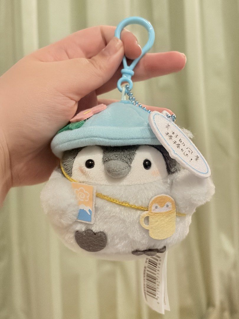 Koupen-chan Plush Charm (Category: Plushies & Soft Toys) located in Caloocan City. Submitted by miffuph (Listing ID 1465125970, Image 1). Description: - Super soft and fluffy penguin plush keychain - Wears an adorable light blue hat with a pink flower - Holds a cute mini travel postcard and cup bag - Features a speech bubble tag that says "美好的风景，最棒棒哒！" - Equipped with a convenient blue plastic clip and beaded chain - Brand new with original tags 