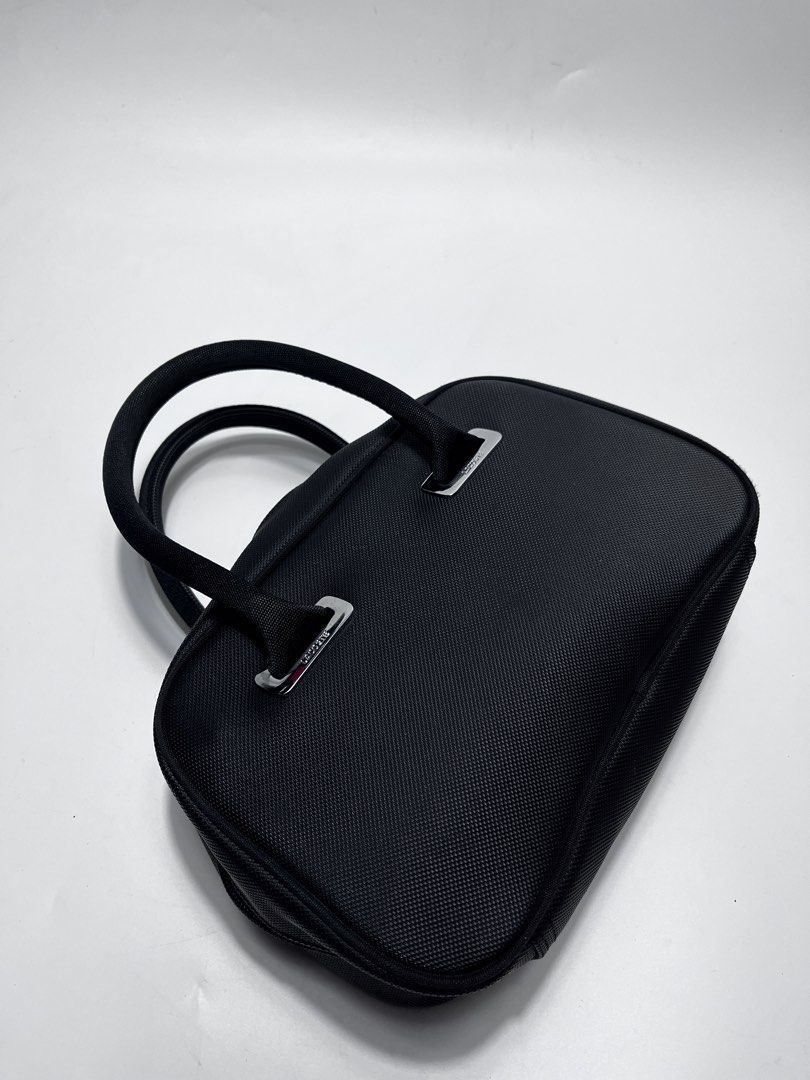 Lacoste Black Handbag (Category: Tote Bags) located in Iloilo. Submitted by fromthebins.ilo2 (Listing ID 1464969467, Image 2). Description: - Brand: Lacoste - Color: Classic Black - Material: Durable textured nylon with silver-tone hardware - Design: Structured shape with sturdy twin handles and debossed crocodile logo - Closure: Secure double zip top closure - Condition: Clean stitching throughout, well-maintained / Excellent or no issues - Size