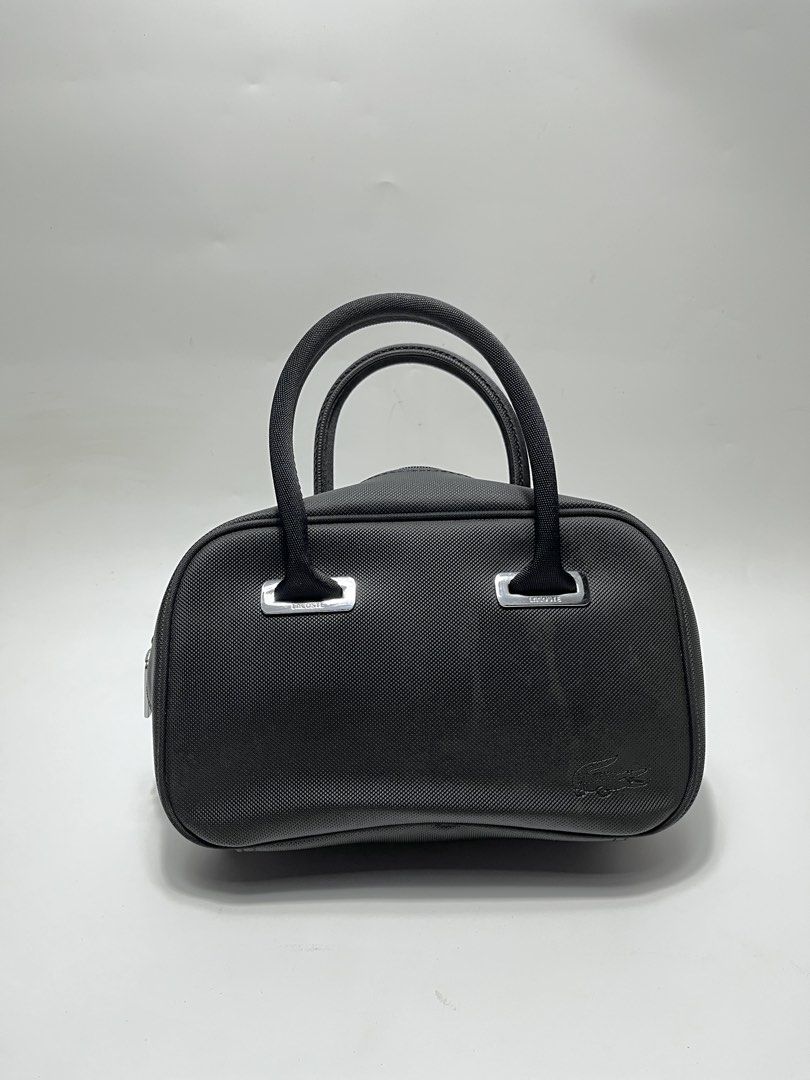 Lacoste Black Handbag (Category: Tote Bags) located in Iloilo. Submitted by fromthebins.ilo2 (Listing ID 1464969467, Image 1). Description: - Brand: Lacoste - Color: Classic Black - Material: Durable textured nylon with silver-tone hardware - Design: Structured shape with sturdy twin handles and debossed crocodile logo - Closure: Secure double zip top closure - Condition: Clean stitching throughout, well-maintained / Excellent or no issues - Size