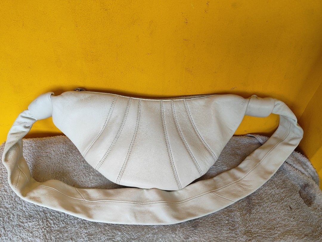 Lemaire White Croissant Shoulder Bag (Category: Luxury Bags & Wallets) located in Cebu City. Submitted by cherreymie70208 (Listing ID 1456723807, Image 2). Description: -Authentic Lemaire Croissant bag - Unique white leather shoulder bag - Trendy croissant shape with elegant pleats - Stylish knotted strap detail - Secure zipper closure - Ideal for everyday wear and carrying your essentials.