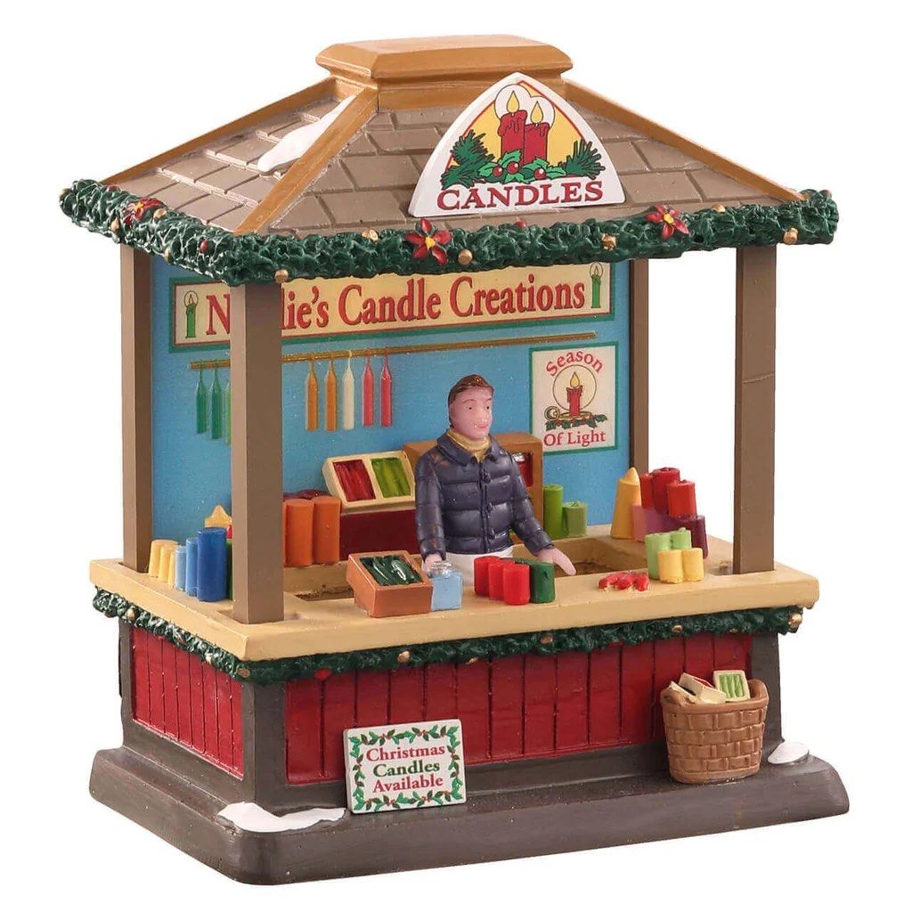 Lemax Natalie’s Candle Creations lighted (Category: Figurines & Statues) located in Santiago. Submitted by kitalpanga (Listing ID 1465057703, Image 1). Description: - Hand-painted miniature Christmas village candle shop stall - Features a festive vendor surrounded by colorful candles and hanging displays - Detailed design with snow-dusted roof, evergreen garlands, and poinsettia accents - Made of durable polyresin material - Great addition to hol