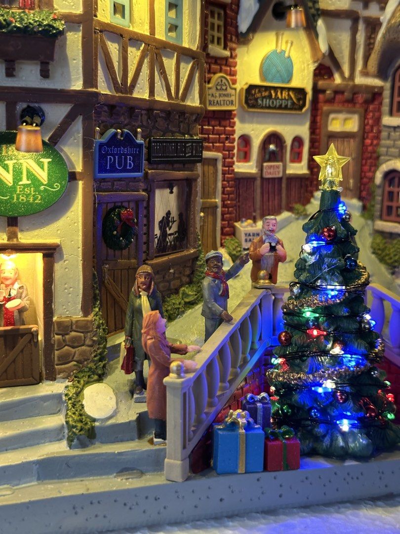 Lemax Oxfordshire Village (Category: Figurines & Statues) located in Santiago. Submitted by kitalpanga (Listing ID 1465066251, Image 3). Description: Battery operated / 4.5v adaptable - Detailed Christmas village scene complete with the Village Inn, Yarn Shoppe, and David's Book Store - Features a glowing center Christmas tree and warm lit windows - Includes miniature figurines walking across the bridge and streets - Designed with intricate brick