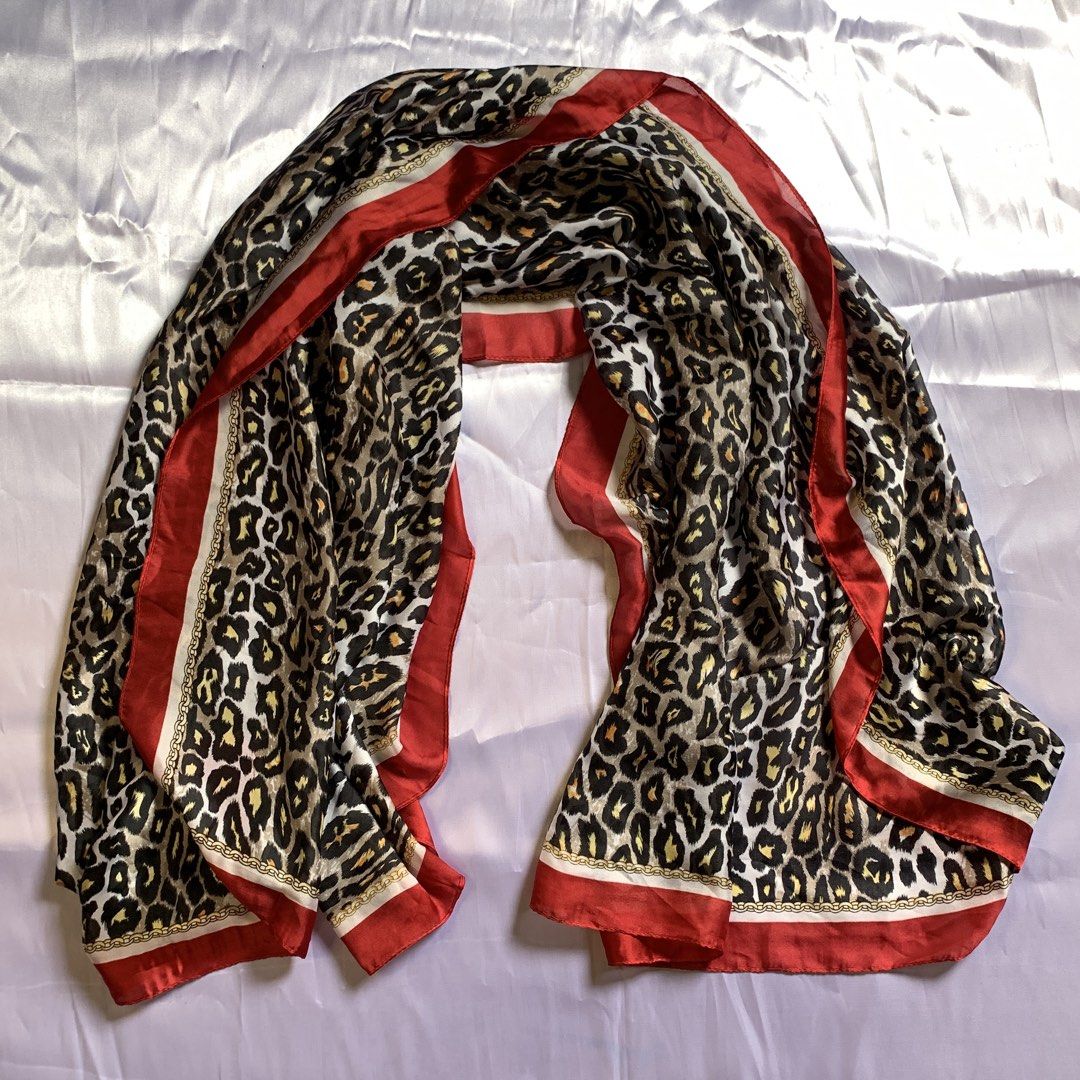Leopard Print Scarf with Red Border and Chain Pattern (Category: Scarves) located in Rizal. Submitted by shop_ms.lai (Listing ID 1464972517, Image 2). Description: - Material: 100% smooth, lightweight polyester with a silk-like feel - Design: Bold leopard print with a chic gold chain border and vibrant red trim - Versatile: Easy to drape around the neck or tie as a stylish bag accessory - Styling Tip: Adds a pop of color and personality to neutra