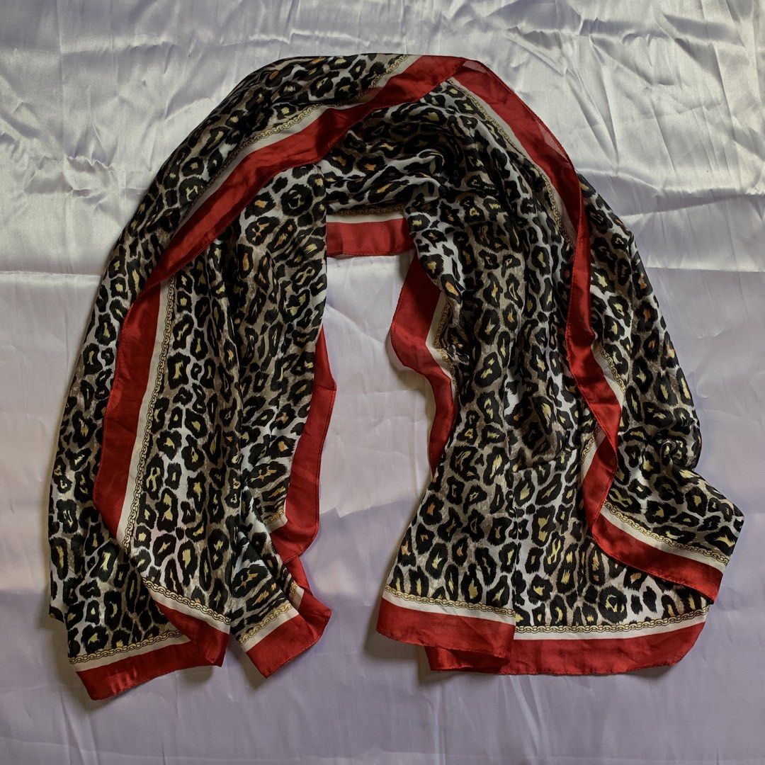 Leopard Print Scarf with Red Border and Chain Pattern (Category: Scarves) located in Rizal. Submitted by shop_ms.lai (Listing ID 1464972517, Image 3). Description: - Material: 100% smooth, lightweight polyester with a silk-like feel - Design: Bold leopard print with a chic gold chain border and vibrant red trim - Versatile: Easy to drape around the neck or tie as a stylish bag accessory - Styling Tip: Adds a pop of color and personality to neutra