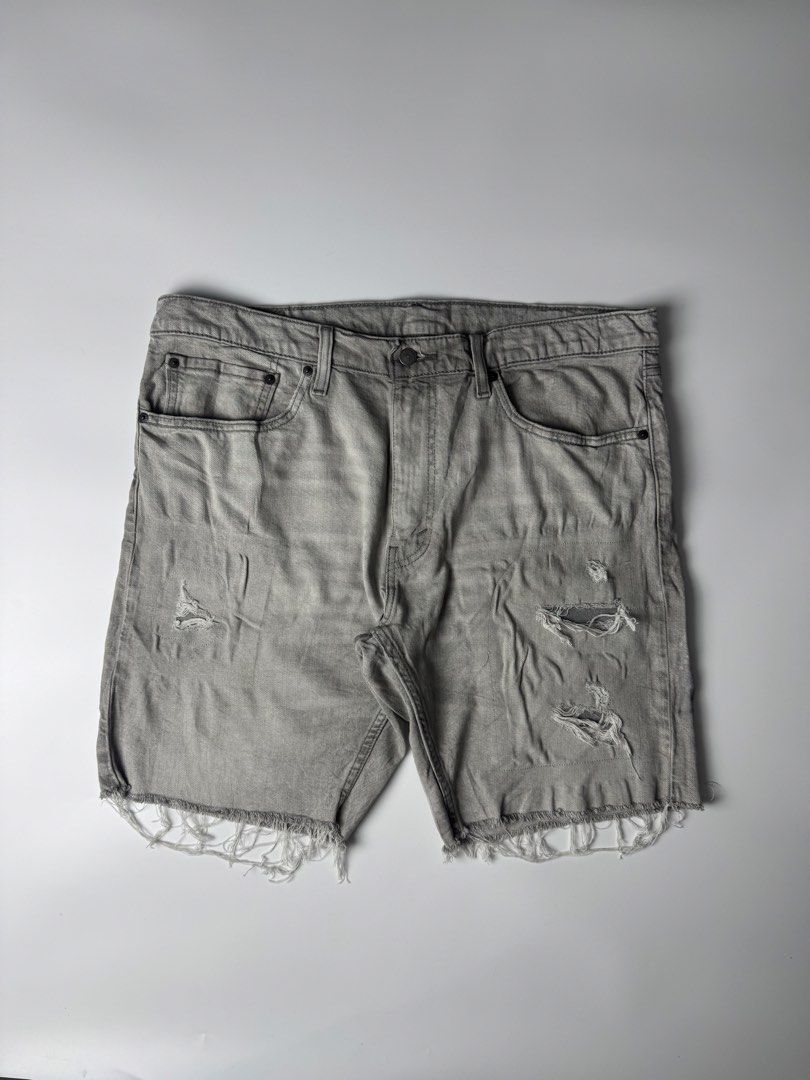 Levi's 412 Distressed Grey Denim Shorts Size 38 (Category: Shorts) located in Cavite. Submitted by dracokidstuff (Listing ID 1465085636, Image 1). Description: - Brand/Model: Levi's 412 grey denim shorts - Style: Distressed with front/back pocket rips and raw frayed hem - Details: Button fly closure and classic back leather patch - Measurements: ~20" across waist (lying flat), ~21" total length - Flaws: Faint dark smudge on the back near the hem 