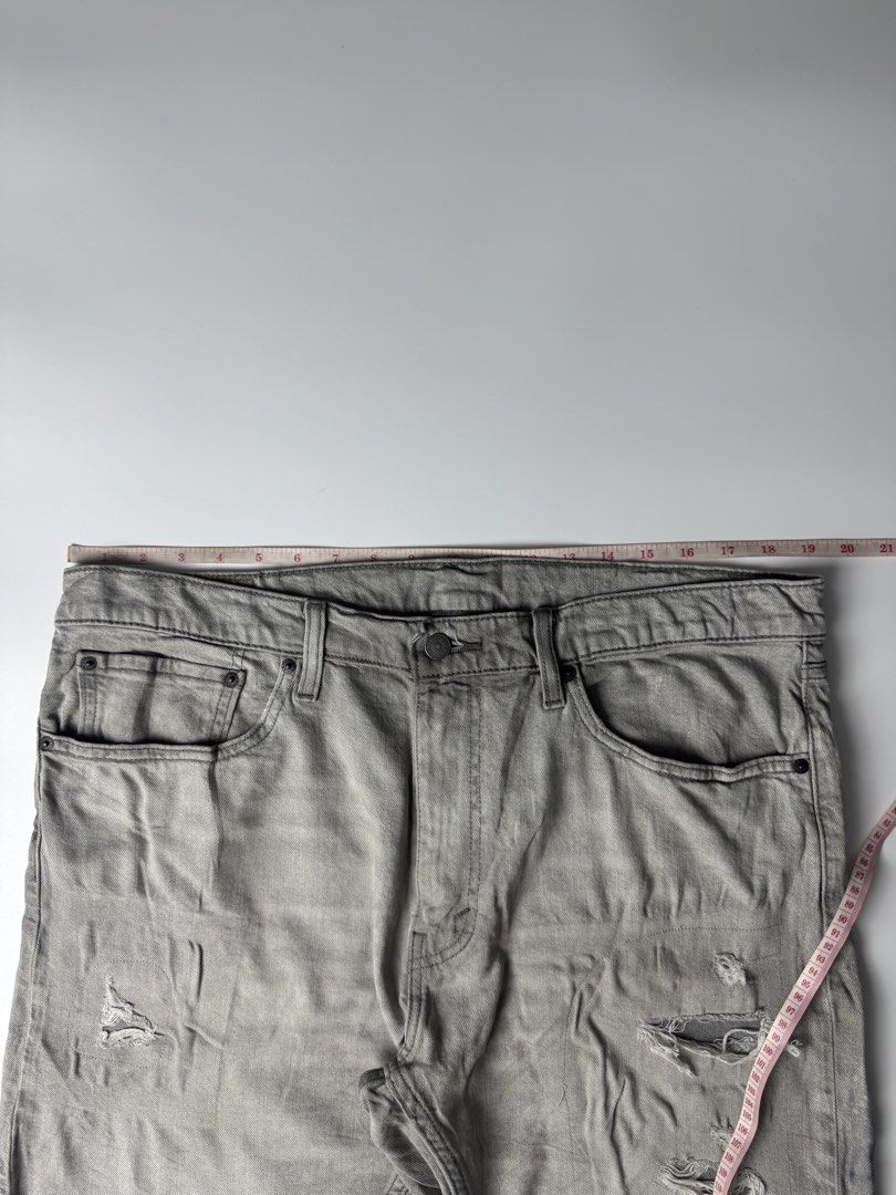 Levi's 412 Distressed Grey Denim Shorts Size 38 (Category: Shorts) located in Cavite. Submitted by dracokidstuff (Listing ID 1465085636, Image 3). Description: - Brand/Model: Levi's 412 grey denim shorts - Style: Distressed with front/back pocket rips and raw frayed hem - Details: Button fly closure and classic back leather patch - Measurements: ~20" across waist (lying flat), ~21" total length - Flaws: Faint dark smudge on the back near the hem 