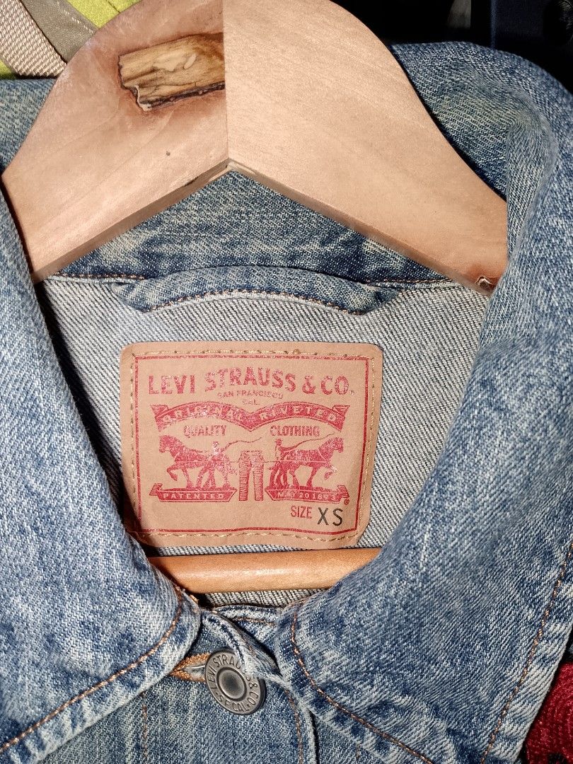 Levi's Denim Jacket Don't Disturb Patch Size XS (Category: Coats, Jackets and Outerwear) located in Manila. Submitted by mjthrifted_second (Listing ID 1465025781, Image 2). Description: - Brand: Levi's - Size: Extra Small (XS) -Dimes: 18/23 - Color: Classic Blue - Design: Embroidered red heart patch with 'DON'T DISTURB' lettering - Features: Front metal button closures, dual button-flap chest pockets, and side welt pockets - Origin: Made in Sri L